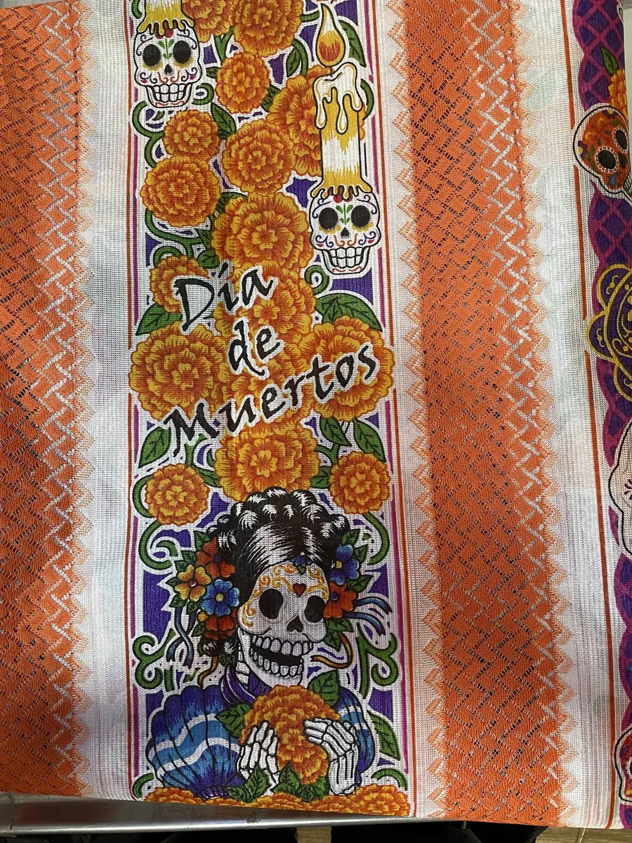 Orange woven tablecloth with a printed panel of marigolds, sugar skulls and candles