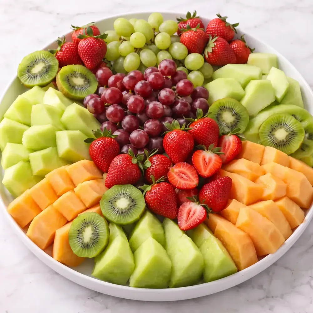 Deluxe fruit platter with melon, grapes, strawberries and kiwi