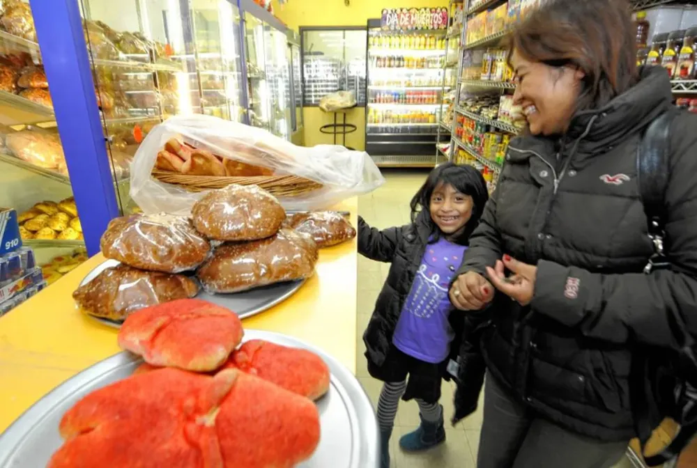 Trays of pan de muerto on the counter as customers shop