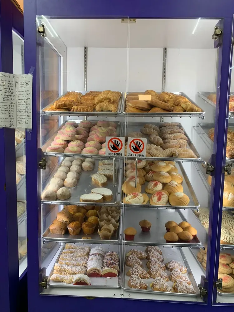 Display case filled with conchas, muffins and pastries